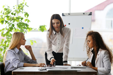 Three young businesswomen at the meeting in a conference room