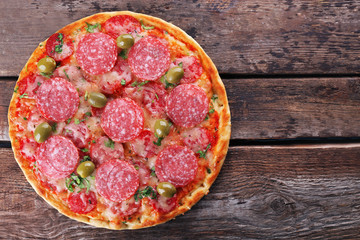Delicious tasty pizza on wooden background