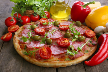 Delicious tasty pizza with ingredients on table, closeup