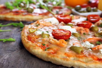 Delicious tasty pizzas with ingredients on table, closeup