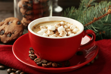 Mug of hot chocolate with marshmallows, fir tree branch on wooden background