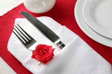 Table setting with plates, napkin and cutlery on red background
