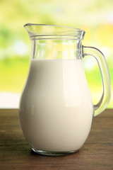 Jar of milk on blurred natural background