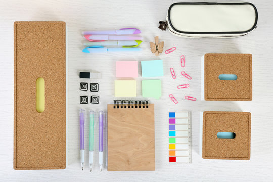 Notebook with stationery and pencil case on a white table