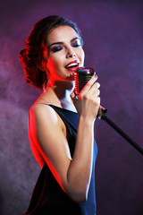 Portrait of beautiful singing woman on purple background