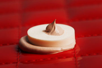 Makeup sponge with liquid foundation on abstract background