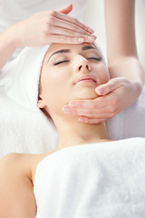Fototapeta na wymiar Spa concept. Face massage. Young woman getting spa treatment, close up
