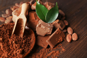 Aromatic cocoa and chocolate on wooden background, close up
