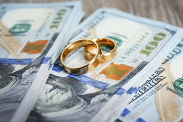 Wedding rings on money background, close up