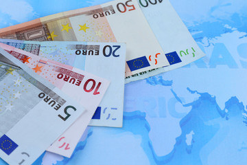 Different euro banknotes on a map background