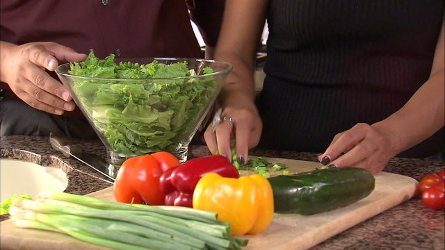 Couple preparing a salad together.
