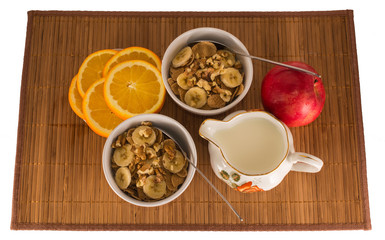 Muesli with walnuts, bananas, cut oranges and apples