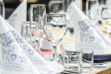 A banquet table with wineglasses and serviettes