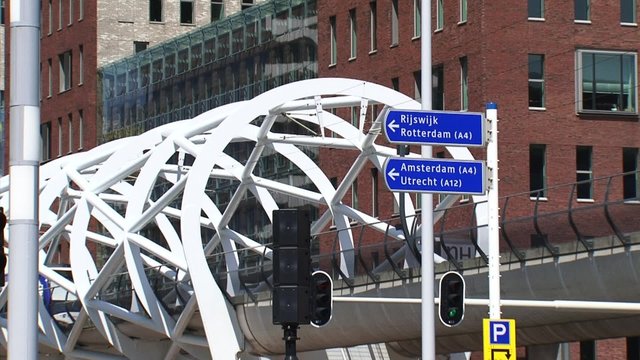 THE HAGUE, Direction sign in Business center Bezuidenhout, RandstadRail viaduct + arriving train in background. THE NETHERLANDS  