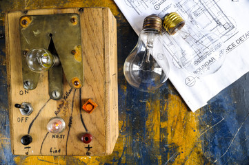 Homemade lightbulb tester with two lightbulbs on paint splattered work table