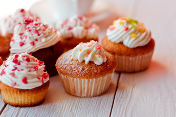 Beautiful cakes cupcakes on a white wooden table