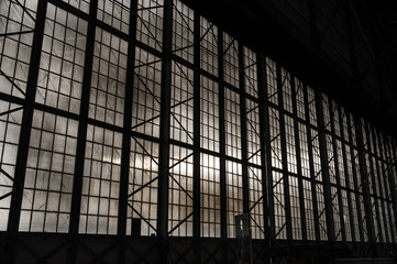 Silhouette of airplane hanger with clouds in background