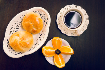Elegant breakfast concept seen from above, coffee cup, bread and sliced oranges