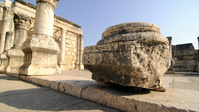 Slow-moving tracking footage of ruined columns in courtyard