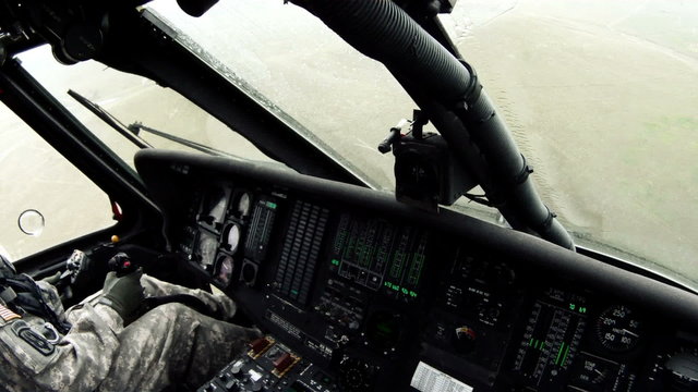 Point of view from Black Hawk copilot flying w/ windshield wipers looking around and at pilot.