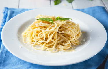 spaghetti with parmesan cheese and basil in plate