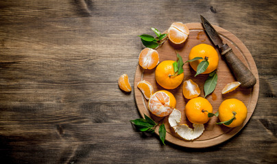 Tangerines with a knife on a chopping Board.