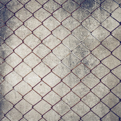 rusty iron chain wire fence on cement wall background