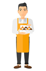 Baker holding box of cakes.