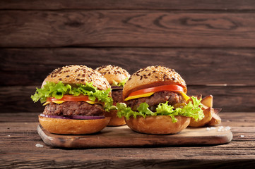 three different burgers on wooden background