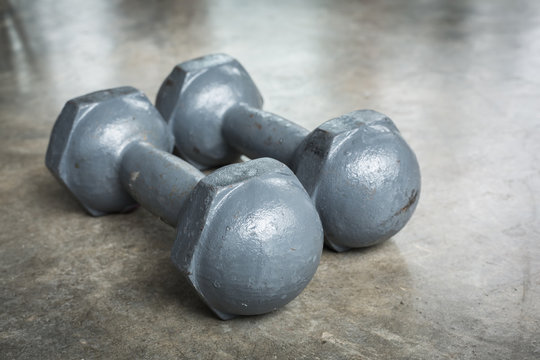 metal dumbbell on cement floor, fitness sport of bodybuilding