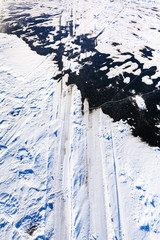 ski tracks on surface of frozen river in winter
