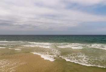 Fototapeta na wymiar aerial view of sandy beach with crashing waves