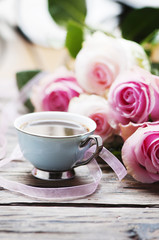 Fototapeta na wymiar Pink roses and coffe on the wooden table