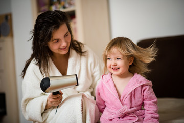 Mother drying hair of her daughter