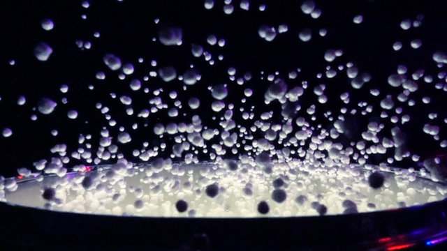 Close up of drum with styrofoam balls for special effect hit in slow motion against black background