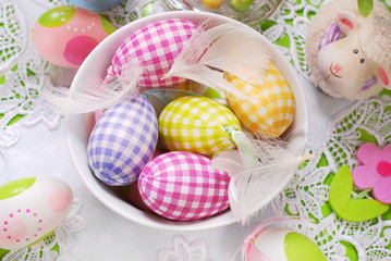 easter eggs and feathers in bowl