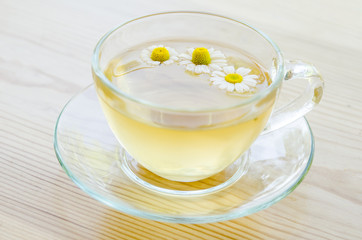Cup of medicinal chamomile tea  on the wooden table