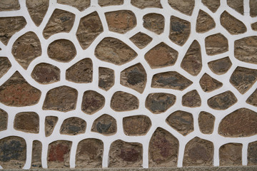 Fototapeta premium wall of brown stones in whtie stucco