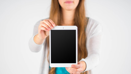 Frau hält ein Smartphone / Tablet mit leerem Display 