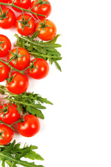 branches of small tomatoes with arugula on a white background