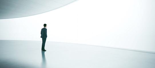 Young businessman wearing suit and stands in the open space interior