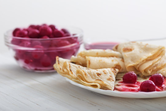 pancakes with  cherries on white wooden table