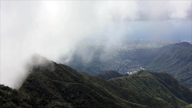 Clouds and fog from the windward side of Oahu climb over the Koolau mountains into Central Oahu and Nuuanu Valley in Hawaii