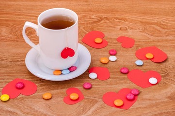 Cup of tea with heart shape on wooden table