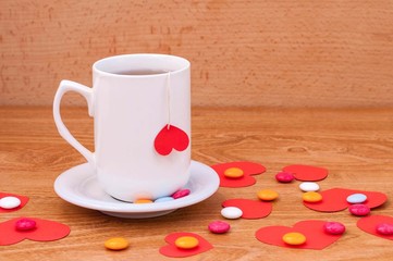 Cup of tea with heart shape on wooden table