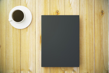 Blank black diary cover with cup of coffee on wooden table, mock