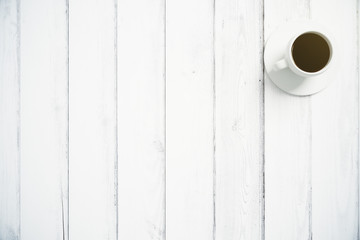 Cup of coffee on white wooden floor