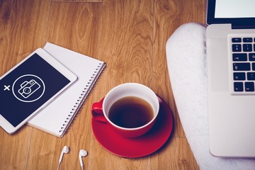 Overhead shot of laptop, tablet, coffee and notebook