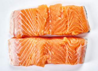 Raw salmon fillets on white