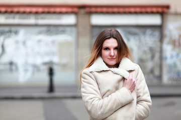 Blonde girl in white leather jacket on the street